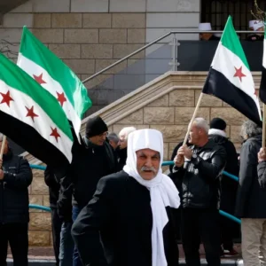 دروز يرفعون العلم السوري في مظاهرة سابقة بمجدل شمس في الجولان السوري المحتل (الفرنسية)