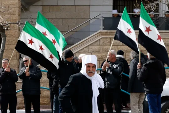 دروز يرفعون العلم السوري في مظاهرة سابقة بمجدل شمس في الجولان السوري المحتل (الفرنسية)